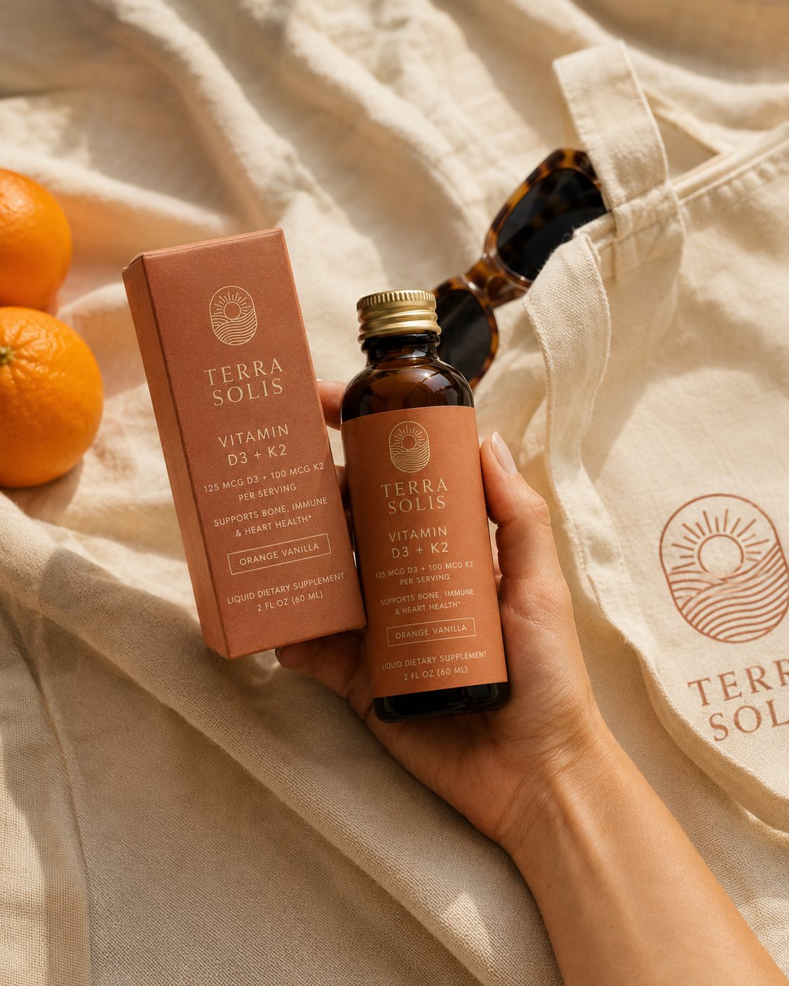 Vitamin D3 + K2 with a tote and oranges outdoors